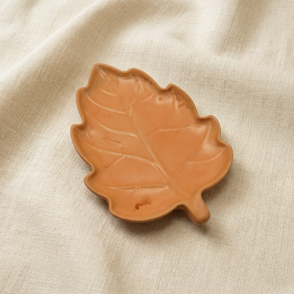 Oak-inspired leaf dish, elevated angle, on ivory linen
