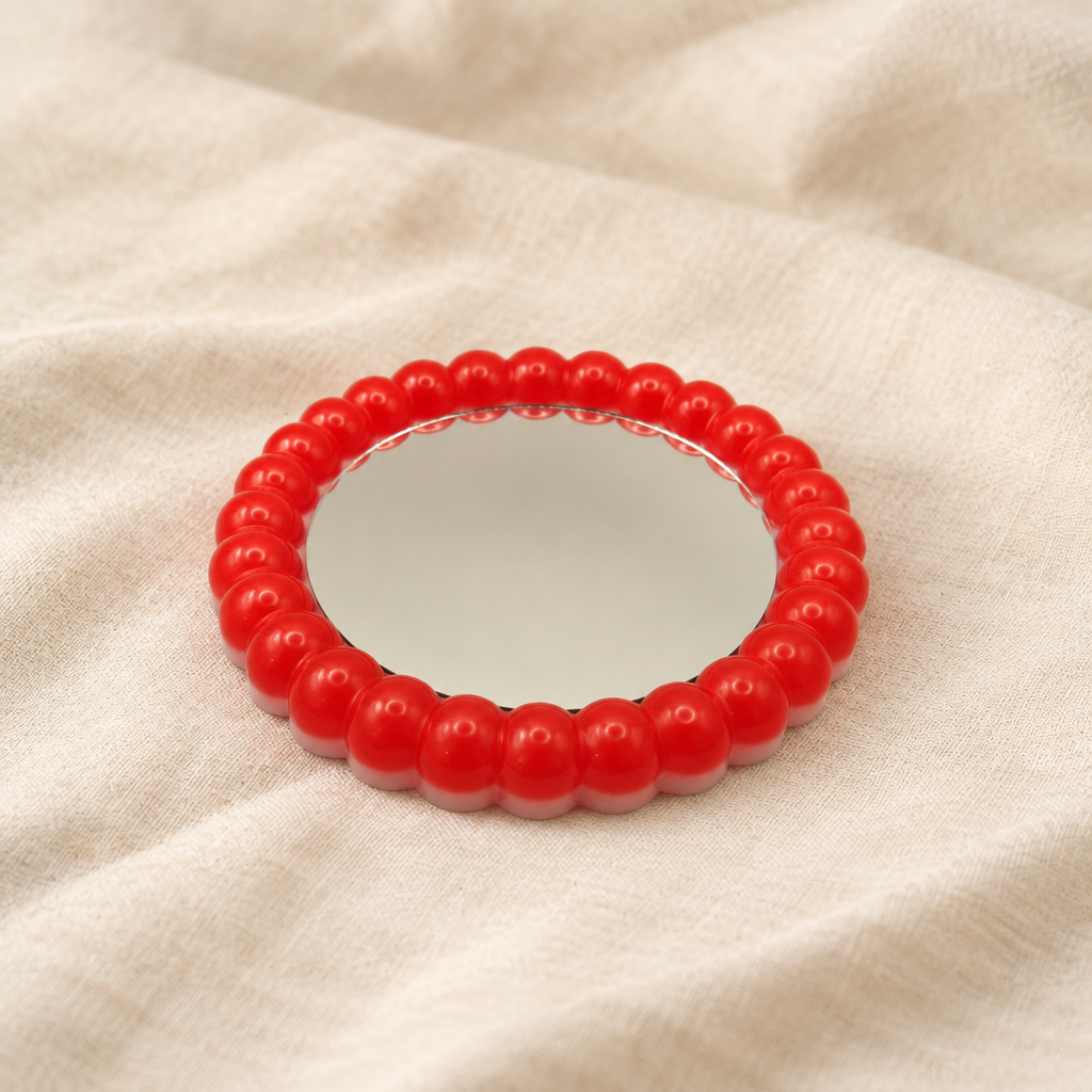 Red-rim mirrored bubble tray alone on soft linen